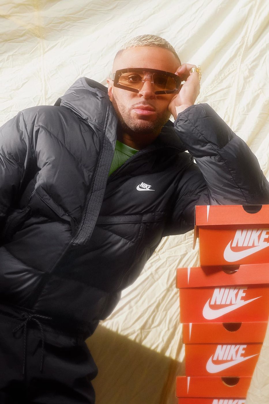 Raul Lopez reclining with stacked Nike shoe boxes